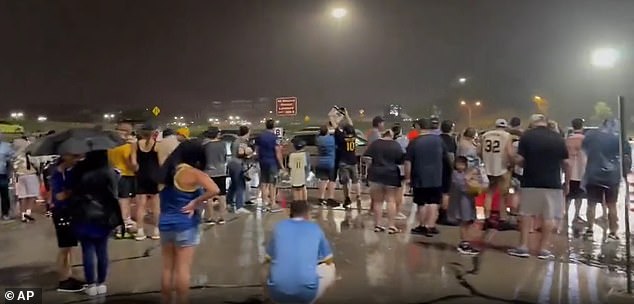 Fans Outside Saturday's Brewers Game Attempt To Navigate The Flooded Parking Lot