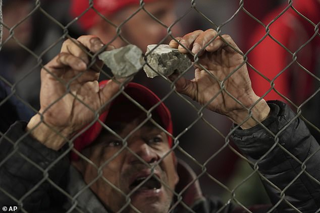 One Fan Holds Up Rocks Which Were Thrown By Supporters During The Clashes Between Fans