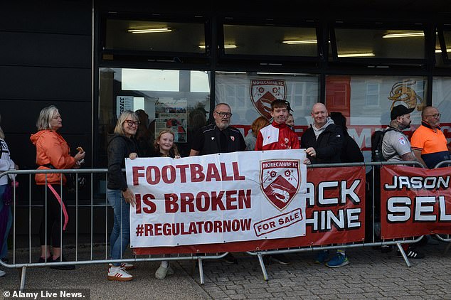 His Appointment Comes Just Days After Morecambe Were Saved From Financial Turmoil (Fans Protesting Above Before A Group Known As Panjab Warriors Won Approval For A Club Takeover)