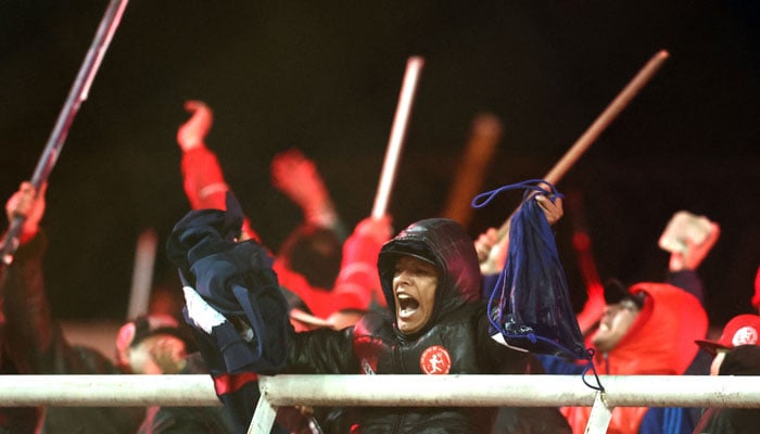Independiente Fans Display Stolen Clothing And Brandish Sticks At The Stands Where Universidad De Chile Fans Were Sitting During The Interruption Of The Copa Sudamericana Round Of 16 Second Leg Football Match Between Argentina’s Independiente And Chile’s Universidad De Chile At The Libertadores De America Stadium In Avellaneda, Buenos Aires Province, Argentina, On August 20, 2025. — Afp