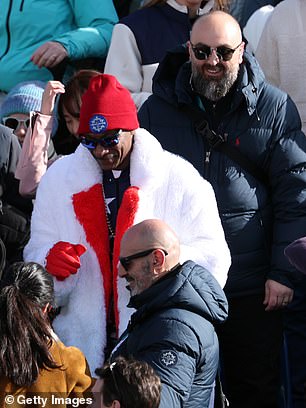A Security Guard Stands Behind The Rapper At The Women's Downhill