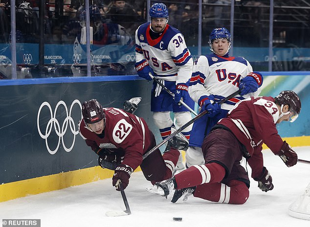 Matthews (Left) And Brock Faber (Right) Of Team Usa Watch Latvian Players Fall To The Ice