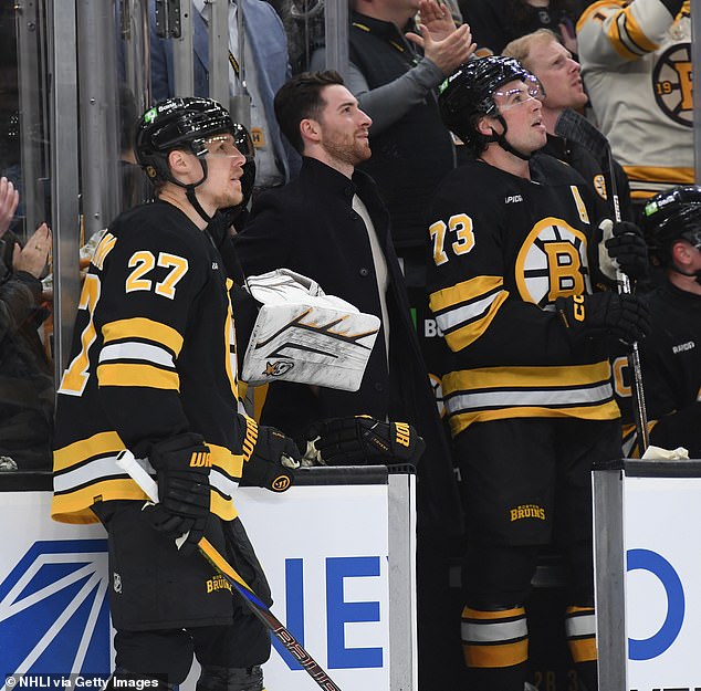 Hampus Lindholm, Jeremy Swayman And Charlie Mcavoy Of The Boston Bruins Watch An Olympics Video Tribute During A Time Out Against The Columbus Blue Jackets