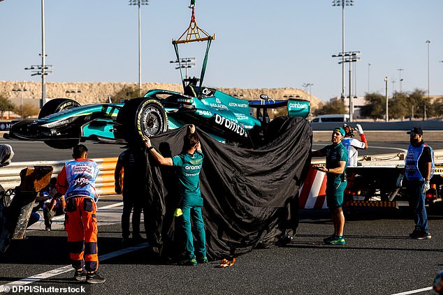 The Amr 26 Car Is Pictured Being Covered Up Before Getting Craned Off The Track In Bahrain After Yet Another Failure